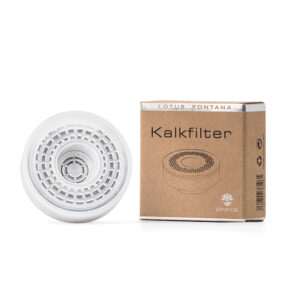 Weißes, wiederbefüllbares Kalkfilter-Gehäuse neben der dazugehörigen Produktverpackung von Lotus Vita.