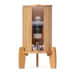 Ein Wasserfilter-Spender aus Glas mit einem Gehäuse und Ständer aus Bambus, der das Wasser filtert und kühlt.