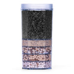 Eine mehrschichtige Wasserfilterkartusche mit verschiedenen Filtermedien wie Aktivkohle und Mineralkugeln in einem durchsichtigen Gehäuse.