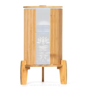 Ein Stand-Wasserfilter mit 8 Litern Fassungsvermögen, umhüllt von einem Lichtschutz aus Bambus, stehend auf einem passenden Bambussockel.