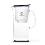 Eine elegante Glas-Filterkaraffe mit schwarzem Deckel und innenliegendem Filterbehälter, verziert mit dem Lotus Vita Logo.